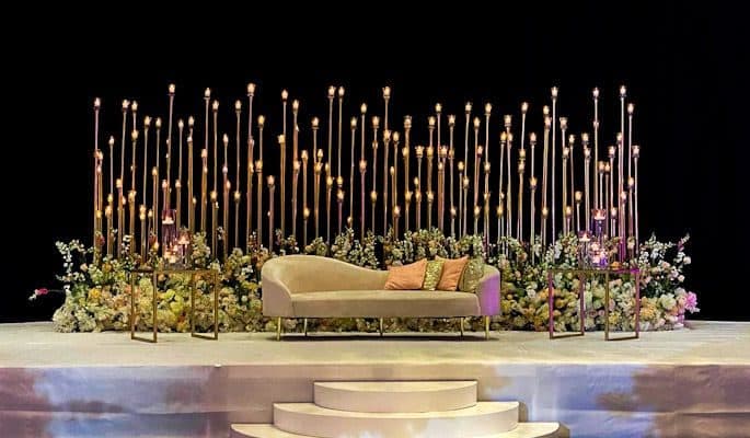 Minimal stage set with tall candle stands and soft florals