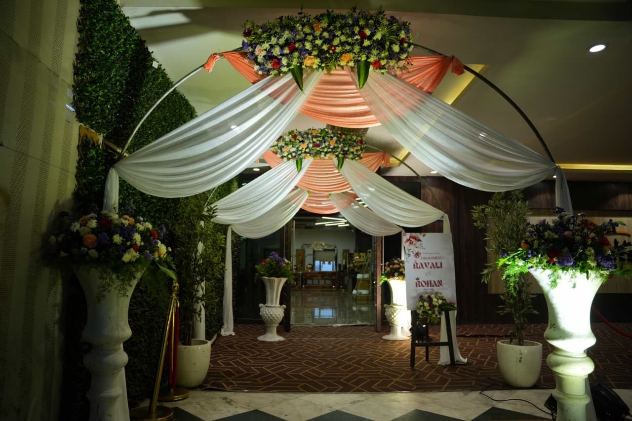 Entrance arch with peach drapes and fresh floral crown