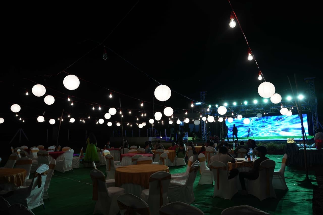 Open-air event under paper lanterns and string lights